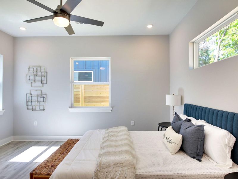 Bedroom featuring multiple windows, ceiling fan, wood finished floors, and recessed lighting