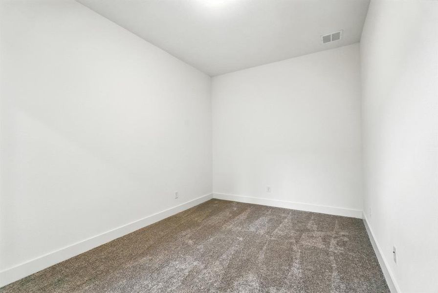 Spare room featuring dark carpet and baseboards Spare room featuring dark carpet and baseboards