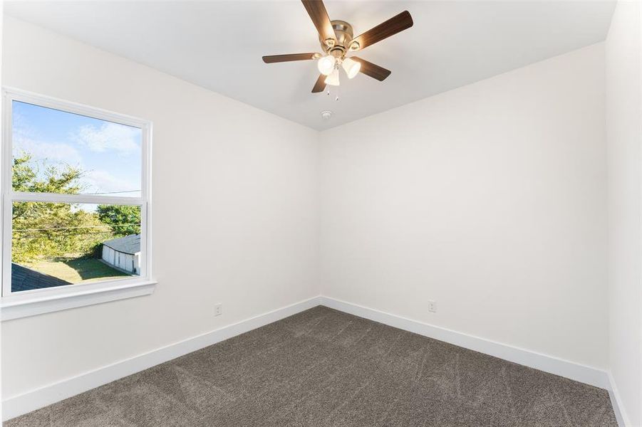 Spare room with dark colored carpet and ceiling fan Spare room with dark colored carpet and ceiling fan