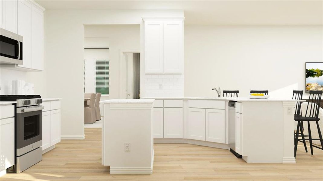 Kitchen with appliances with stainless steel finishes, light wood-type flooring, white cabinetry, and a kitchen island