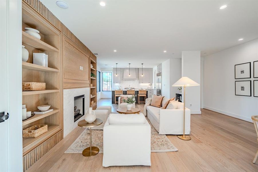 Living area featuring a fireplace, light wood-style flooring, recessed lighting, and built in features