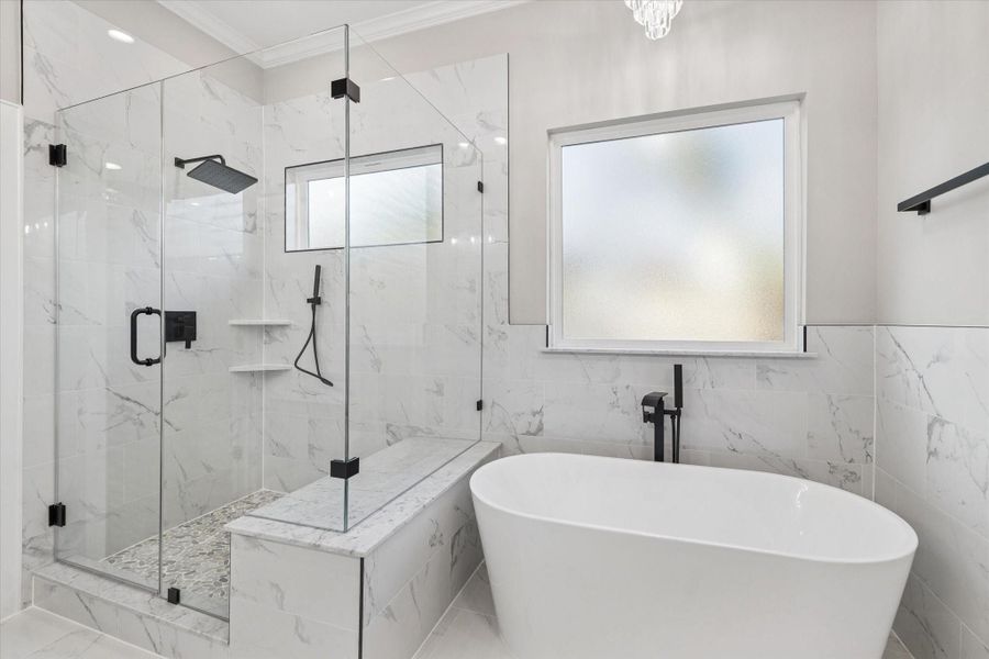 Primary bath frameless shower and garden tub.  Obscure windows and crown molding.