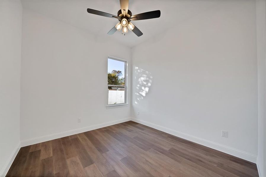 Secondary bedroom with dark wood flooring and ceiling fan
