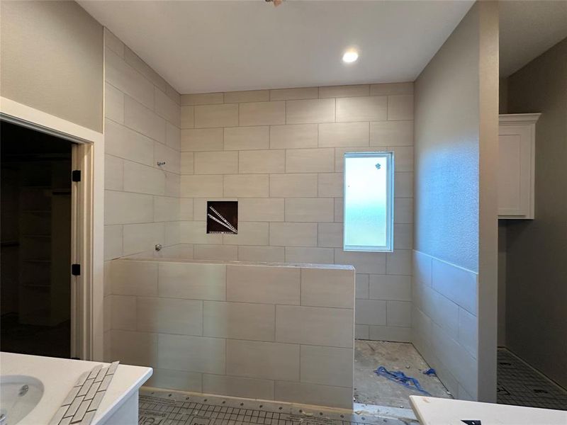 Bathroom featuring a tile shower and vanity