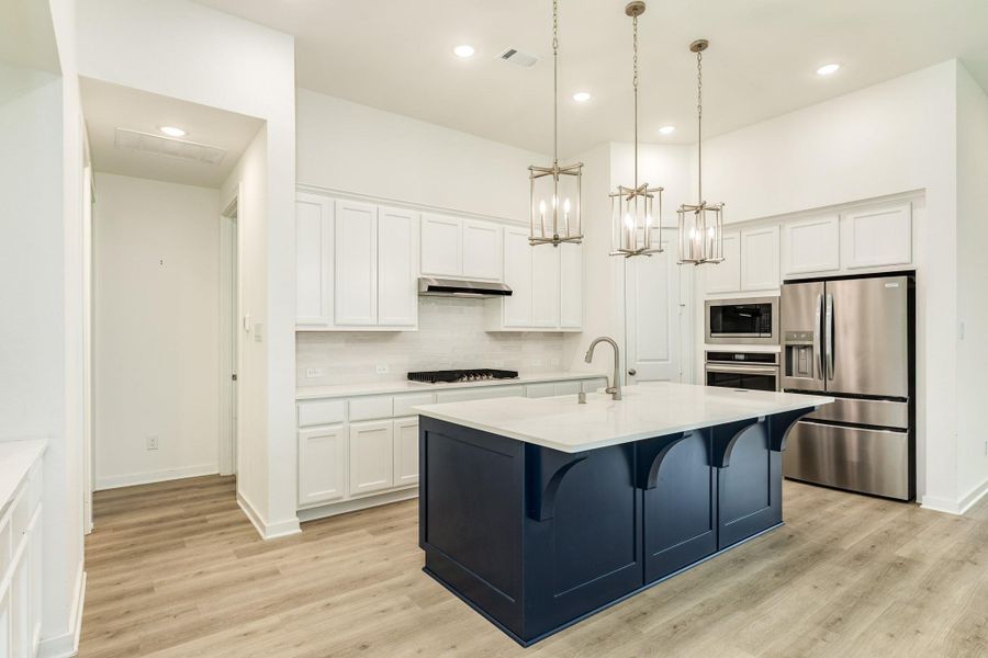 Spacious gourmet kitchen featuring abundant cabinet storage, modern stainless steel appliances, and a convenient breakfast bar perfect for casual dining.