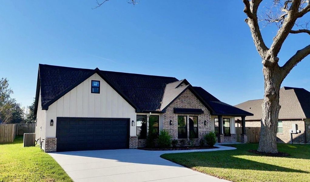 This photo shows a modern ranch-style home with a combination of brick and siding exterior. It features a large two-car garage and a neatly landscaped front yard with a mature tree. The driveway is spacious, and the house has a welcoming entrance with large windows. This photo shows a modern ranch-style home with a combination of brick and siding exterior. It features a large two-car garage and a neatly landscaped front yard with a mature tree. The driveway is spacious, and the house has a welcoming entrance with large windows.