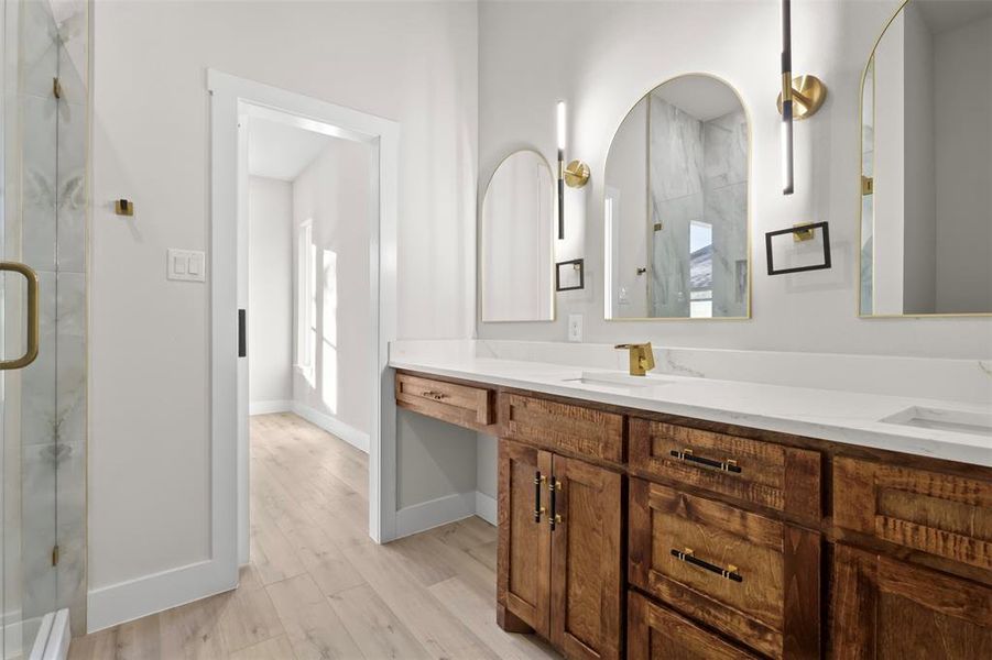 Bathroom with wood-type flooring, vanity, and a shower with door