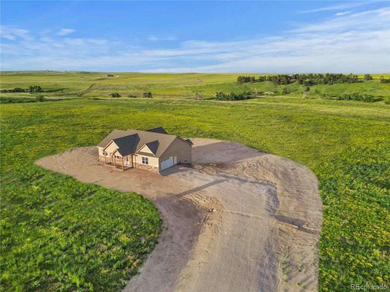 Frontal aerial perspective of the framed home with visible layout and concrete pad for porch.