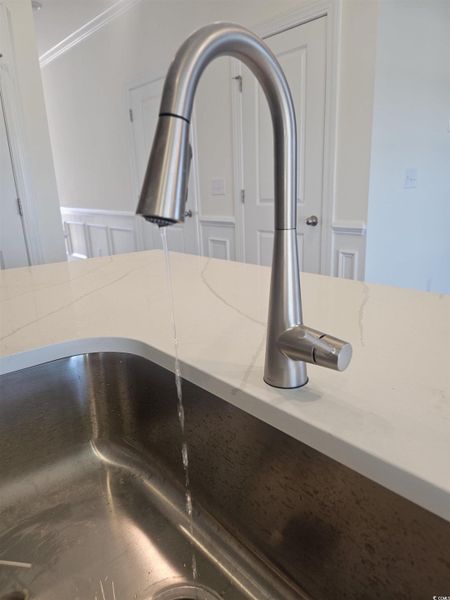 Kitchen view of light stone counters and crown molding