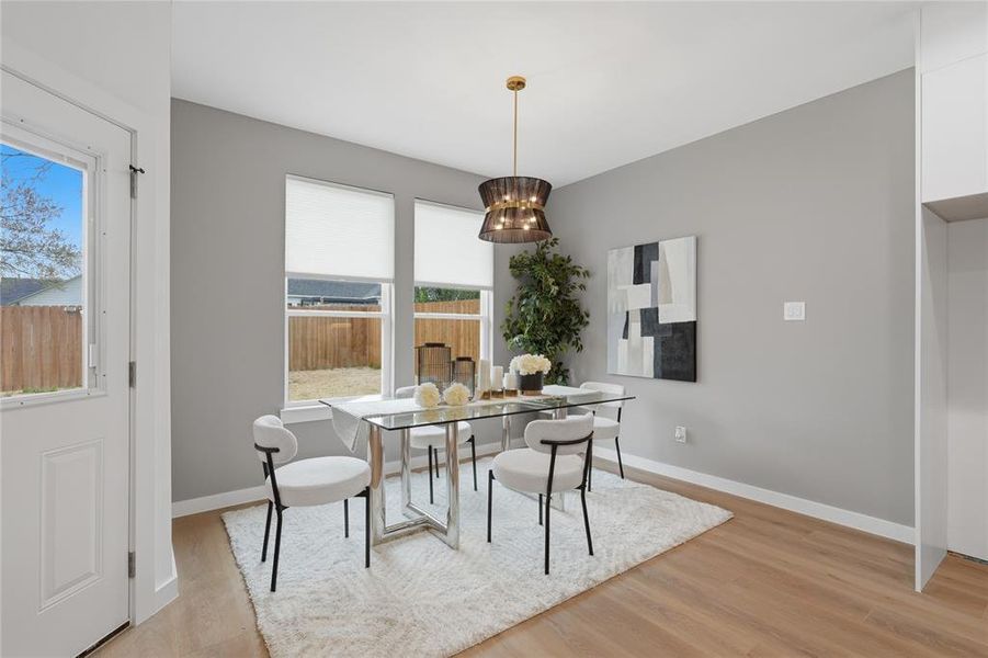 Dining room featuring light wood-type flooring and suspended lighting Dining room featuring light wood-type flooring and suspended lighting