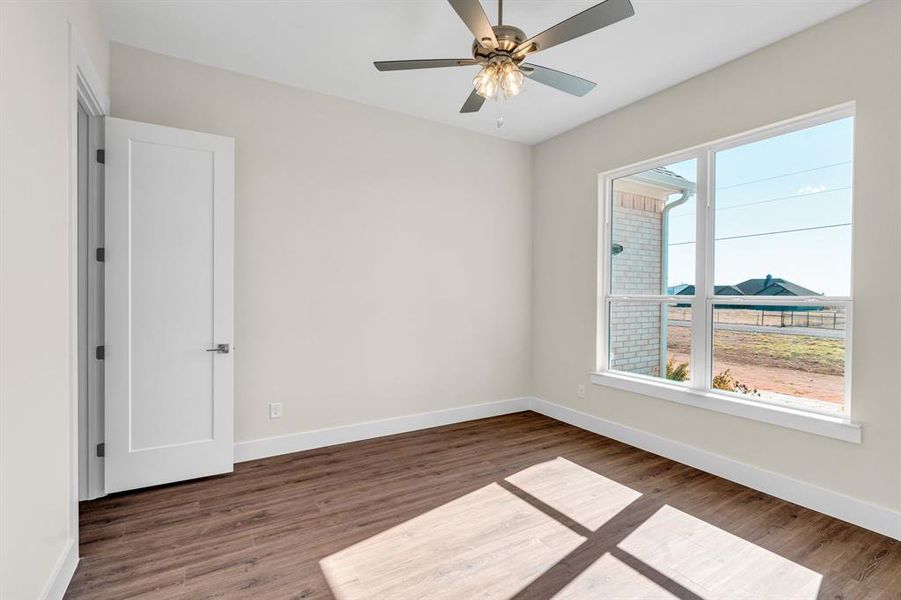 Unfurnished room with ceiling fan, baseboards, and wood finished floors