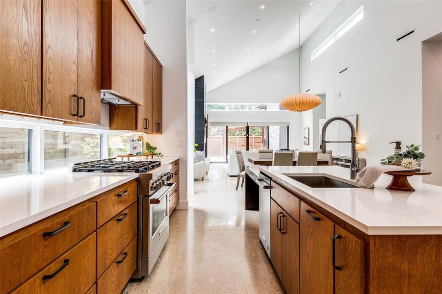 Kitchen with sink, appliances with stainless steel finishes, a center island, and high vaulted ceiling