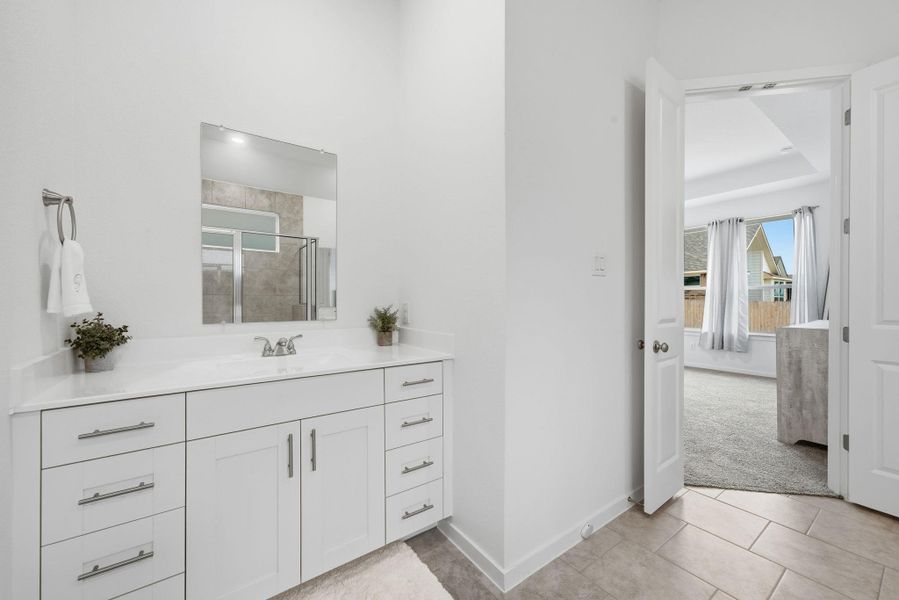 Full bathroom with vanity, light tile patterned floors, and a stall shower