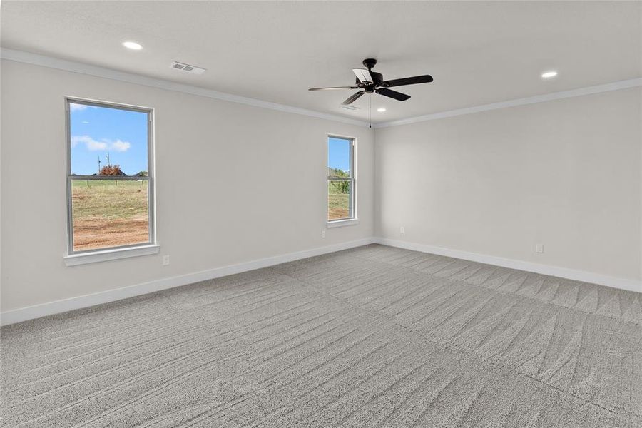 Unfurnished room with ceiling fan, light colored carpet, and ornamental molding