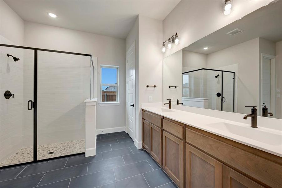 Bathroom with double vanity, a stall shower, dark tile patterned floors, and recessed lighting