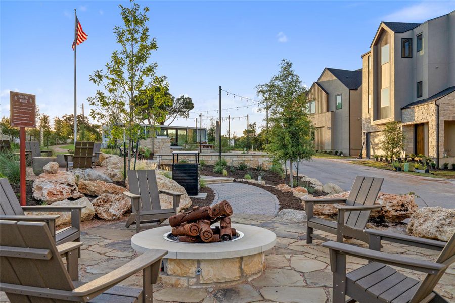 An inviting stone fire pit area beckons with Adirondack chairs, perfect for evening gatherings. An inviting stone fire pit area beckons with Adirondack chairs, perfect for evening gatherings.