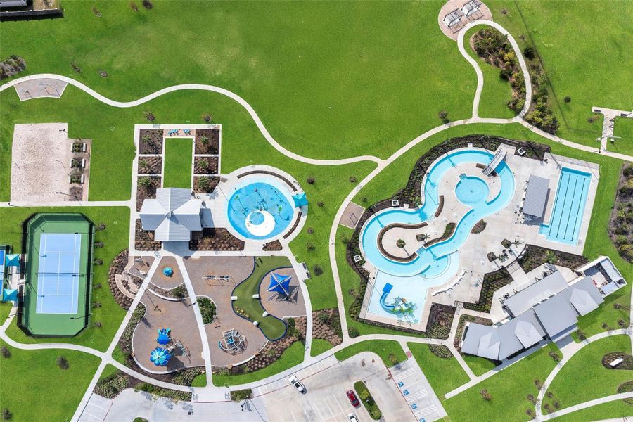 Aerial/angled shot showing the lazy river’s graceful loops surrounded by pool decks and cabanas — pure resort vibes.