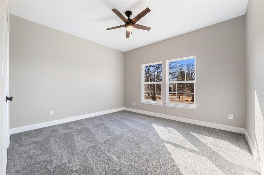 Unfurnished room with ceiling fan and carpet