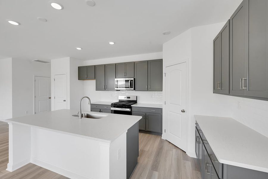 A kitchen with white cabinets.