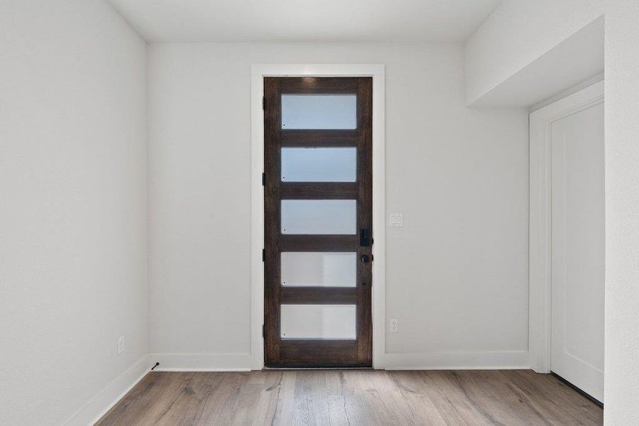 Foyer entrance featuring light wood-style flooring and baseboards