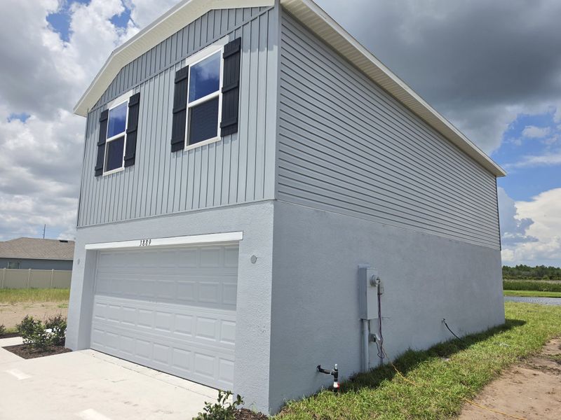 Front exterior of a new home in Lake Deer Estates, Poinciana, FL, highlighting curb appeal (Image 13). Front exterior of a new home in Lake Deer Estates, Poinciana, FL, highlighting curb appeal (Image 13).