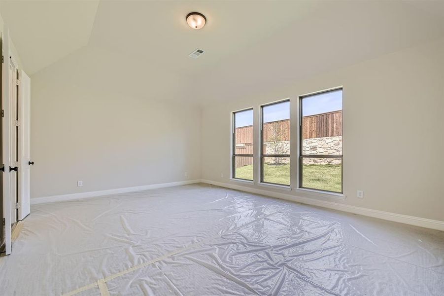 Unfurnished room featuring vaulted ceiling