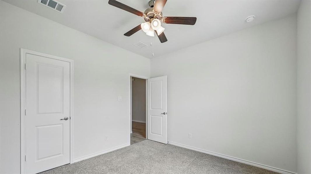 Unfurnished bedroom with carpet flooring and ceiling fan