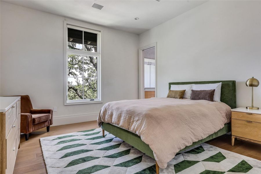Well-lit sleeping quarters with rich hardwood flooring and a picturesque window view.