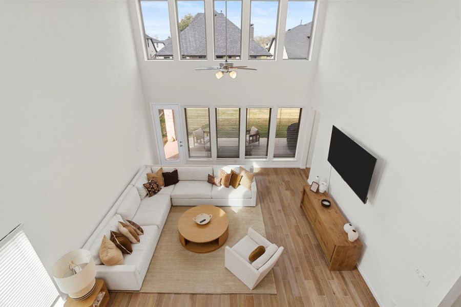 A bird's-eye view from the game room balcony, capturing the grand proportions and light-filled atmosphere of the family room. A bird's-eye view from the game room balcony, capturing the grand proportions and light-filled atmosphere of the family room.