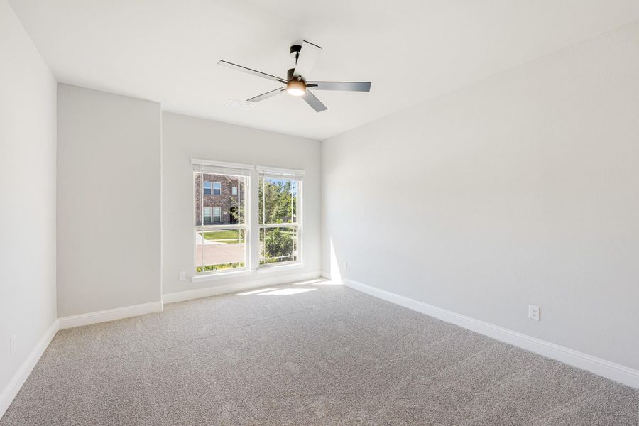 Empty bedroom with gray carpet, ceiling fan, and a window with natural light Empty bedroom with gray carpet, ceiling fan, and a window with natural light