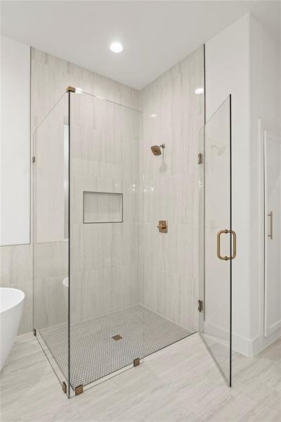 Bathroom featuring a stall shower and a freestanding tub