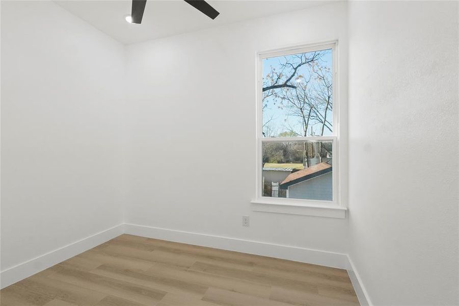Empty room with light wood-type flooring and a ceiling fan