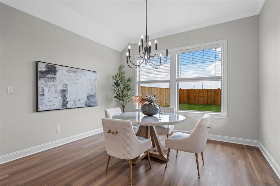 Dining space with light wood finished floors, a chandelier, and lofted ceiling Dining space with light wood finished floors, a chandelier, and lofted ceiling