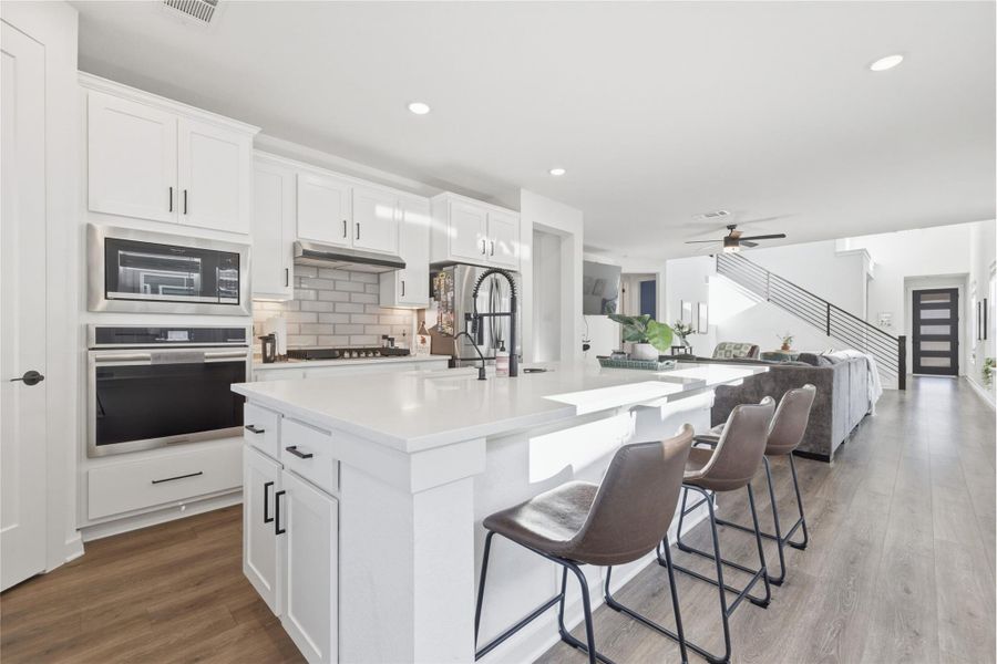Kitchen featuring white cabinetry, stainless steel appliances, dark wood-type flooring, ceiling fan, and recessed lighting