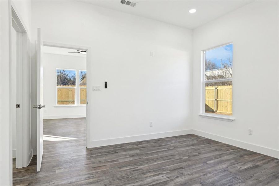 Unfurnished room featuring recessed lighting, visible vents, baseboards, and wood finished floors