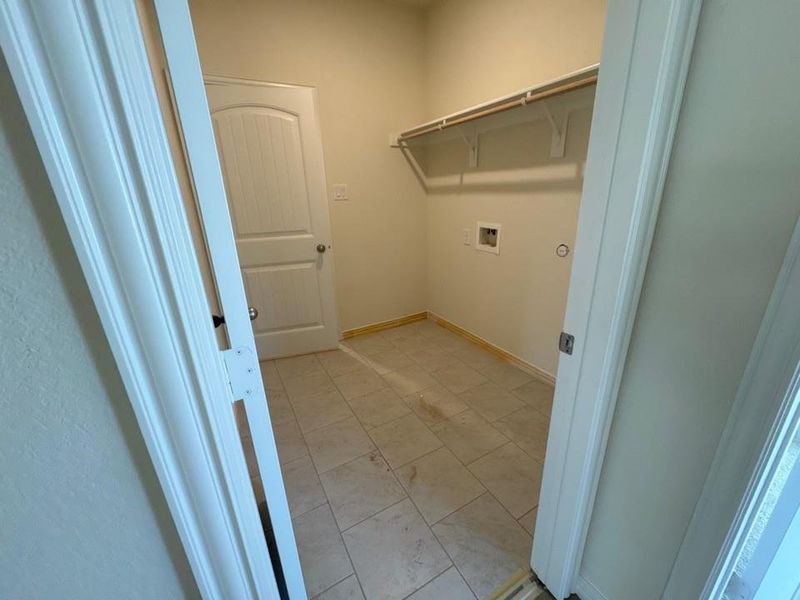 Washroom with hookup for a washing machine and baseboards