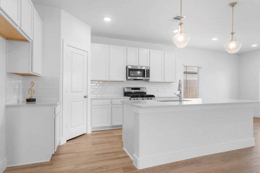 This gourmet kitchen has gorgeous tall white cabinets, large walk-in pantry for all your storage needs and more!