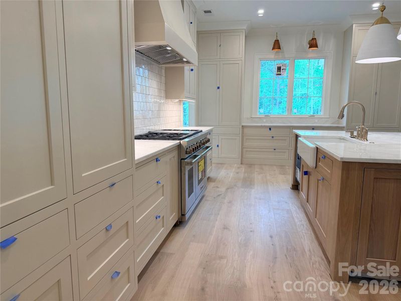 Spacious kitchen with Wolf Gas Range, Subzero 30 x 30" side by side fridge/freezer, farm sink and open views of GR.