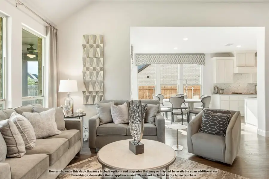 Open-concept living room with gray sofas, hardwood floors, and view into dining area and kitchen