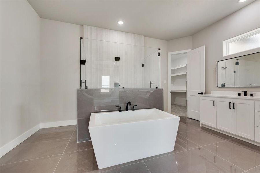 Bathroom with tile patterned flooring, shower with separate bathtub, and vanity