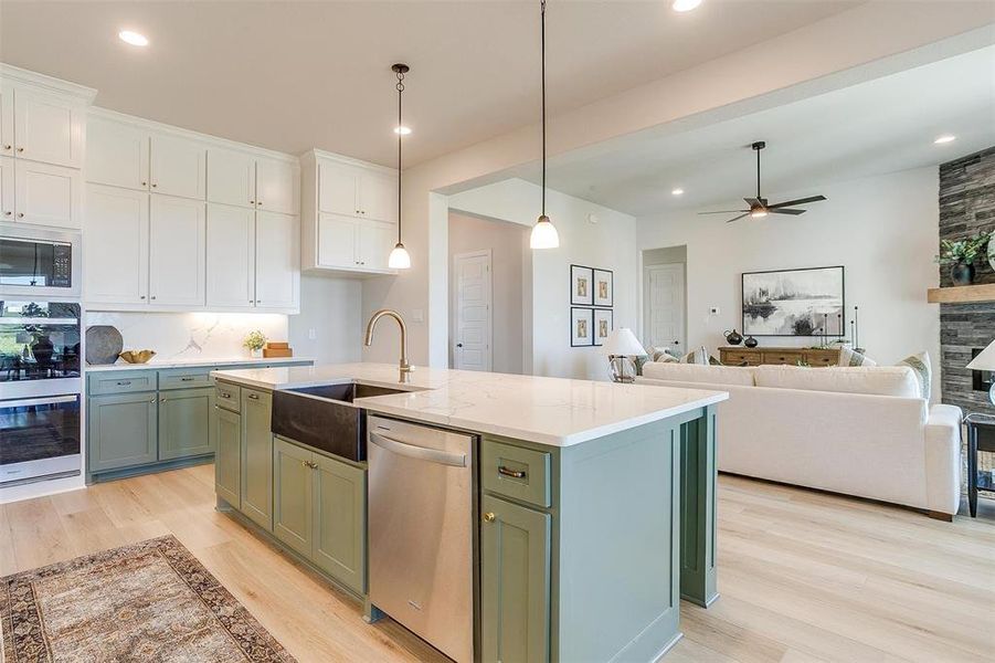 Kitchen featuring light hardwood / wood-style floors, appliances with stainless steel finishes, white cabinetry, and decorative backsplash