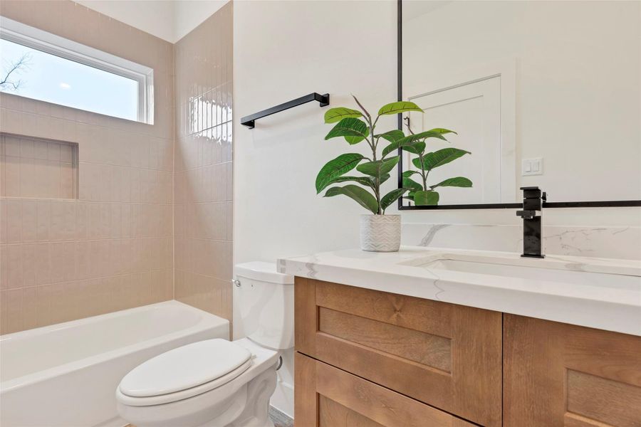 Convenient en-suite bathroom on the first floor, featuring a tub and shower combo along with a single sink for comfort and practicality. Convenient en-suite bathroom on the first floor, featuring a tub and shower combo along with a single sink for comfort and practicality.