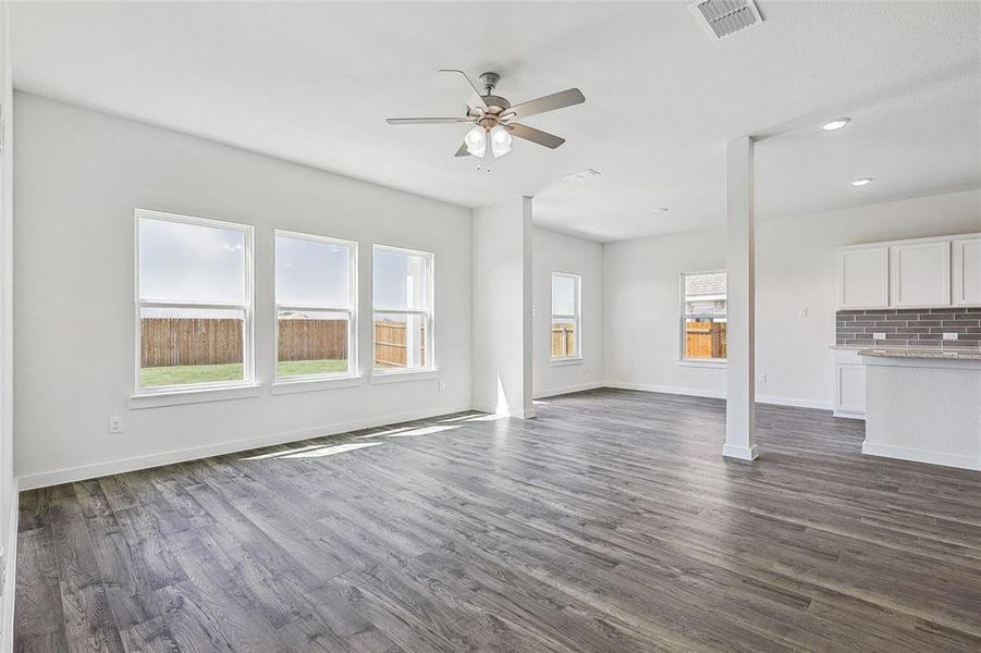 Unfurnished living room with dark hardwood / wood-style flooring and ceiling fan