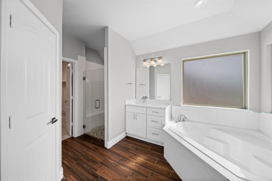 Bathroom featuring vanity, separate shower and tub, and hardwood / wood-style flooring