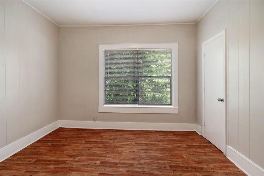 Empty room with dark wood-style floors and crown molding Empty room with dark wood-style floors and crown molding