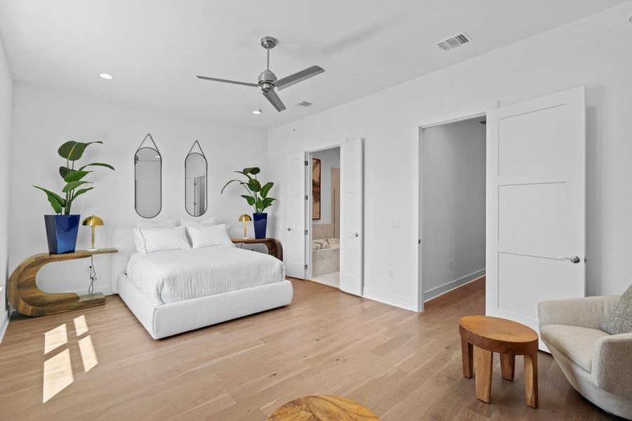 Bedroom with light wood-type flooring, a ceiling fan, recessed lighting, and ensuite bath