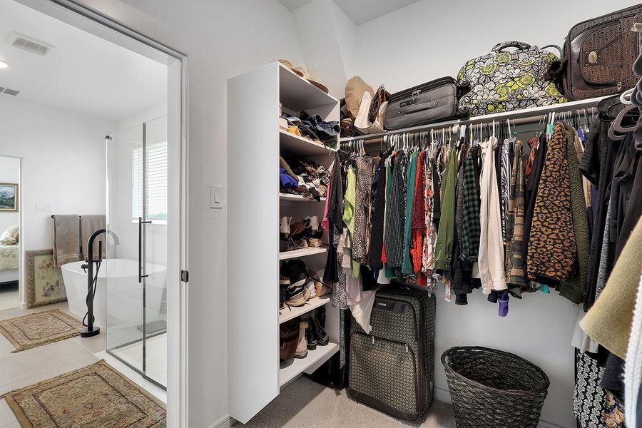 Large primary walk-in closet with ample hanging and shelf space.