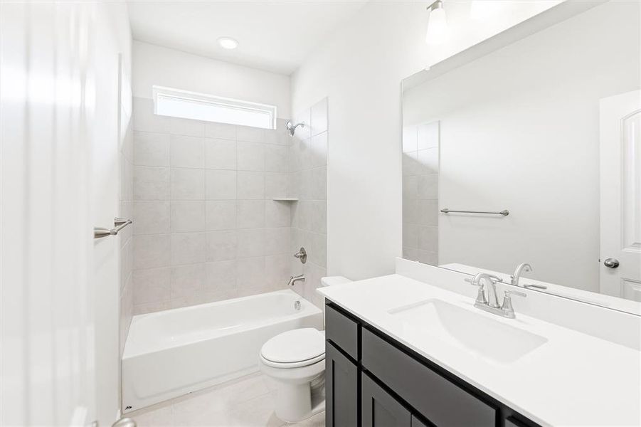 Bathroom featuring shower / tub combination, vanity, and light tile patterned floors