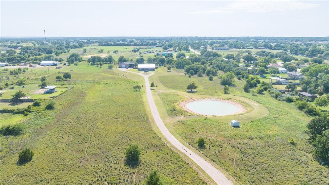 Expansive acreage featuring a private pond, a graded drive, scattered mature trees, and multiple outbuildings Expansive acreage featuring a private pond, a graded drive, scattered mature trees, and multiple outbuildings