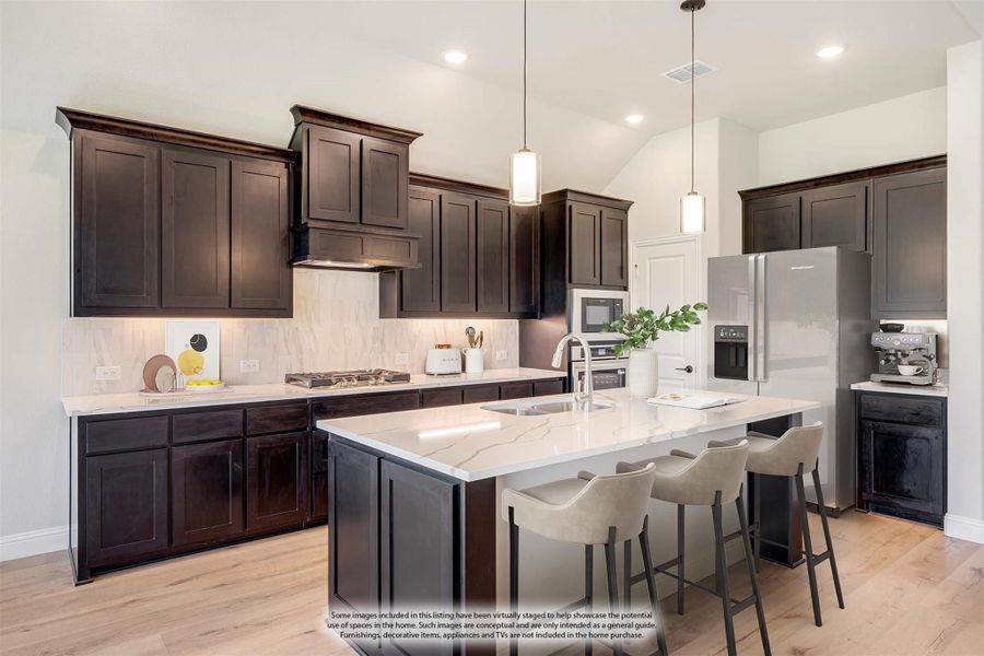 Kitchen with dark wood cabinets, marble countertops, center island with seating, and stainless steel appliances on light hardwood floors Kitchen with dark wood cabinets, marble countertops, center island with seating, and stainless steel appliances on light hardwood floors
